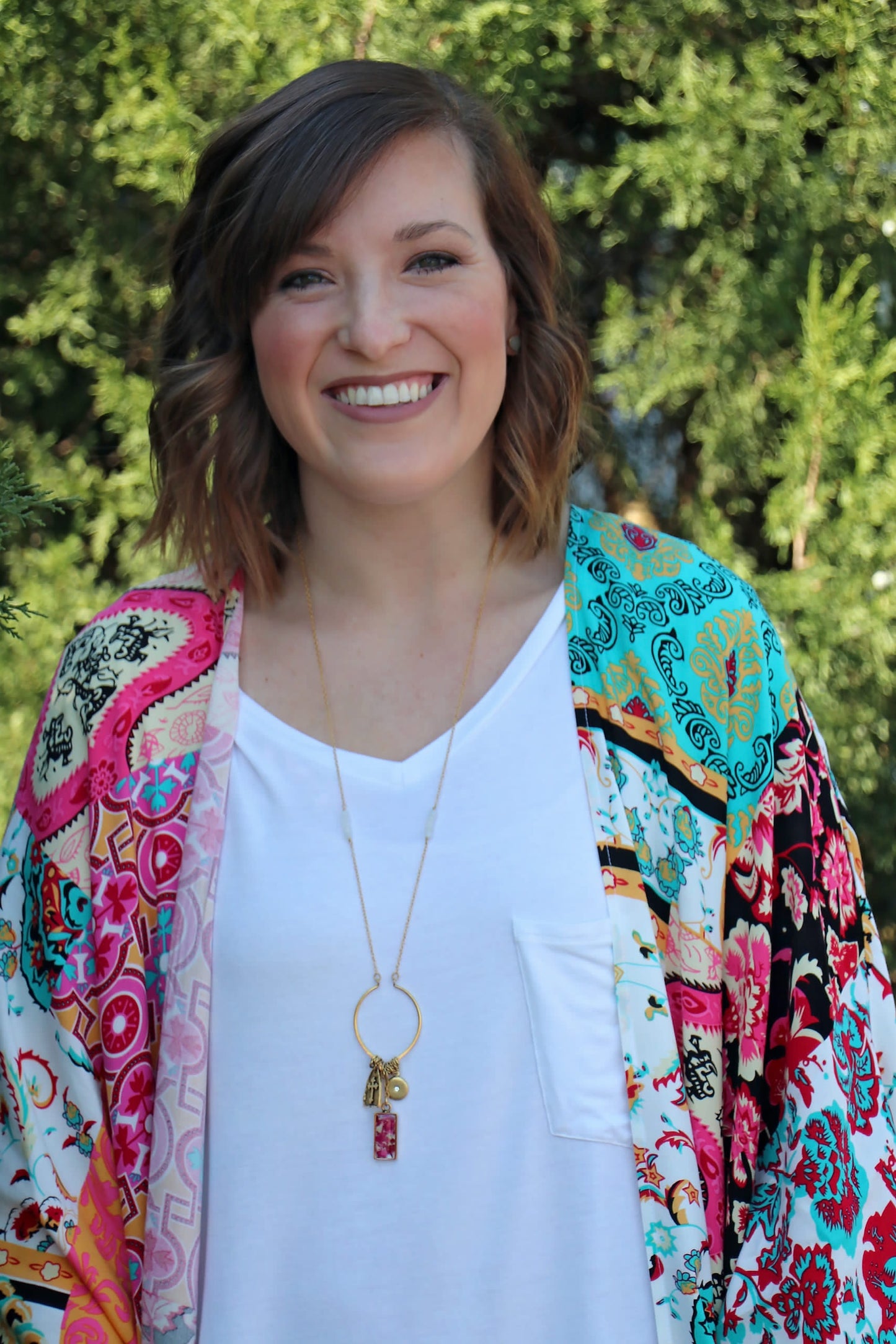 Alex is wearing the Memory Flower Diamond Hoop Charm Necklace -long gold necklace using pink flowers with charms dangling >