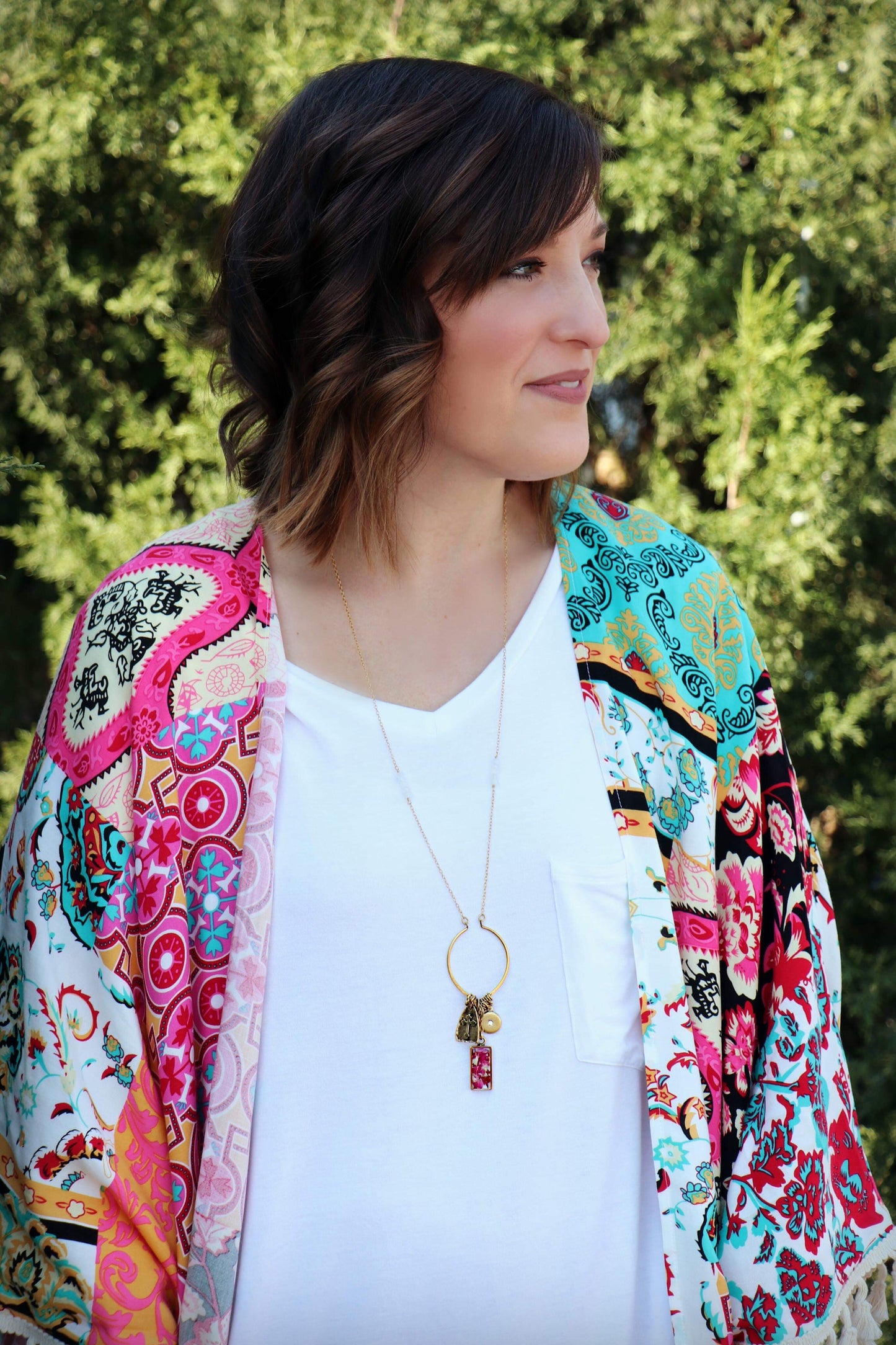 Alex is wearing the Memory Flower Diamond Hoop Charm Necklace -long gold necklace using pink flowers with charms dangling >